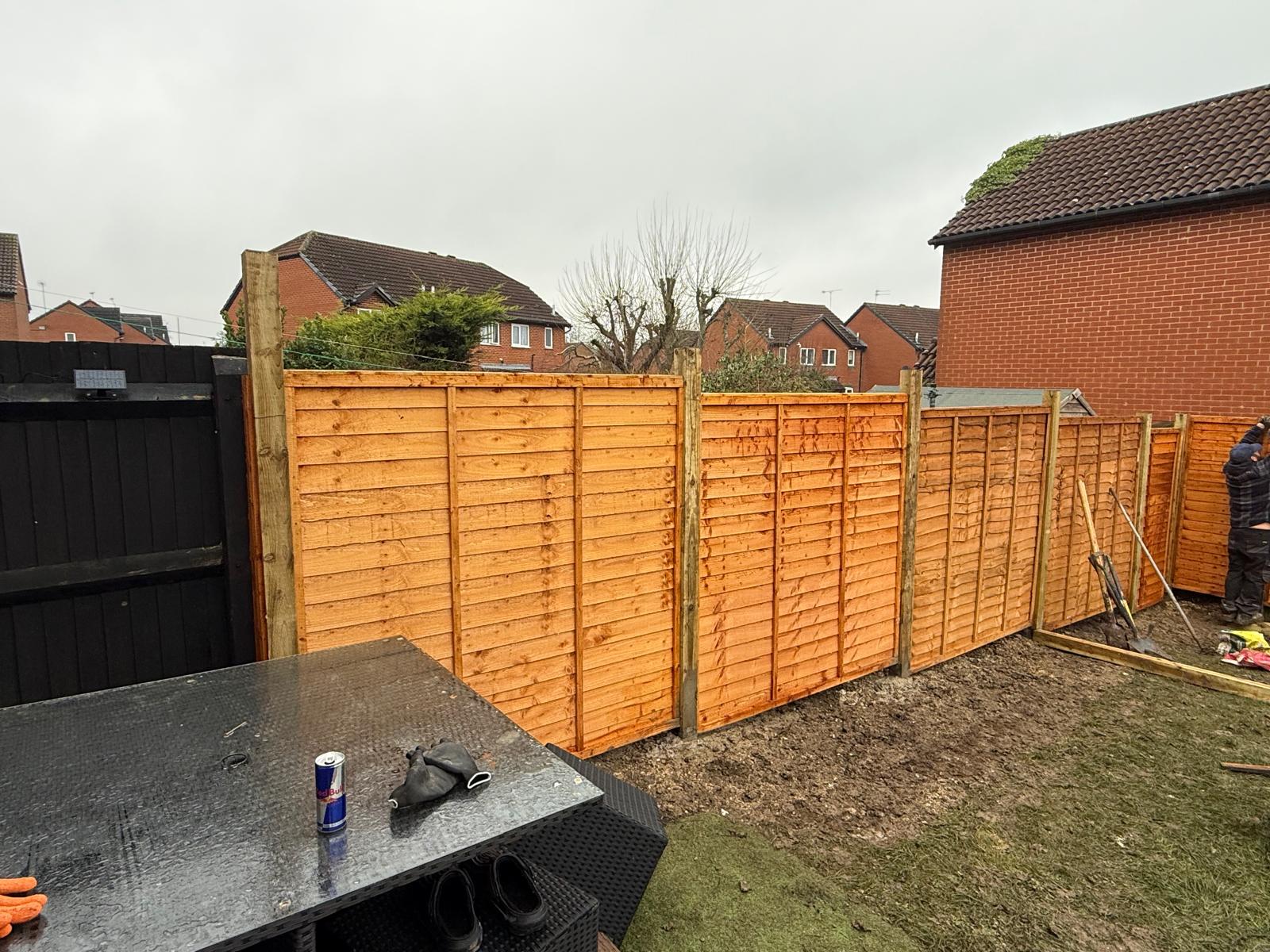 Supplied illustrative stock photo of timber fence panels and posts during installation